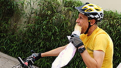 Edu Capivara comendo pão e pedalando